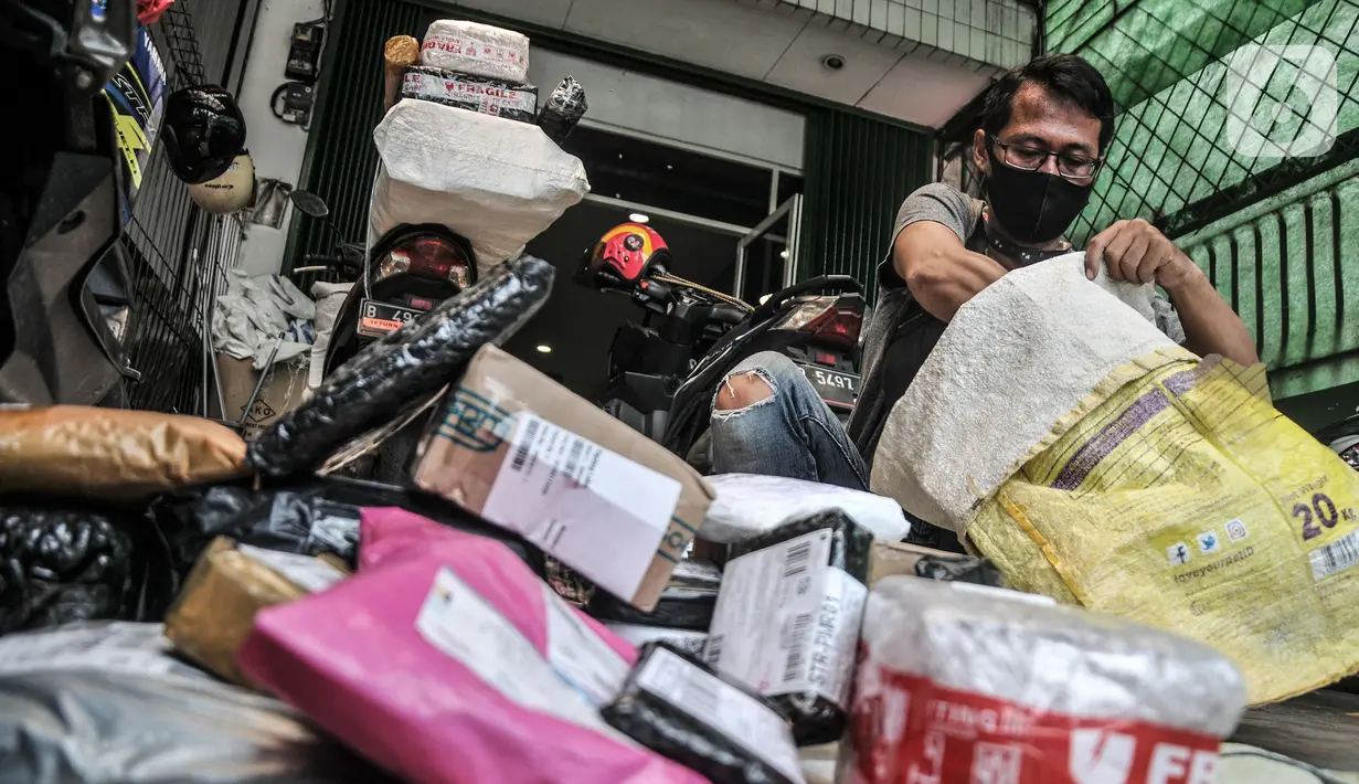 Pekerja menyelesaikan pengemasan paket milik konsumen e-commerce di kantor cabang salah satu perusahaan jasa ekspedisi online, Jakarta, Kamis (23/9/2021). Menteri Perdagangan Muhammad Lutfi mengatakan nilai transaksi dagang elektronik (e-Commerce) naik 63,36 persen. (merdeka.com/Iqbal S. Nugroho)