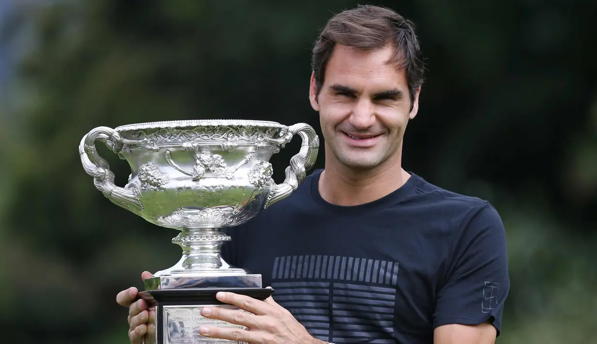 Petenis Swiss, Roger Federer tersenyum saat berpose dengan Piala Challenge Norman Brookes di Government House, Melbourne, Australia (29/1). Federer mengalahkan petenis Kroasia Marin Cilic 6-2, 6-7(5), 6-3, 3-6, 6-1. (AP Photo/Dita Alangkara)