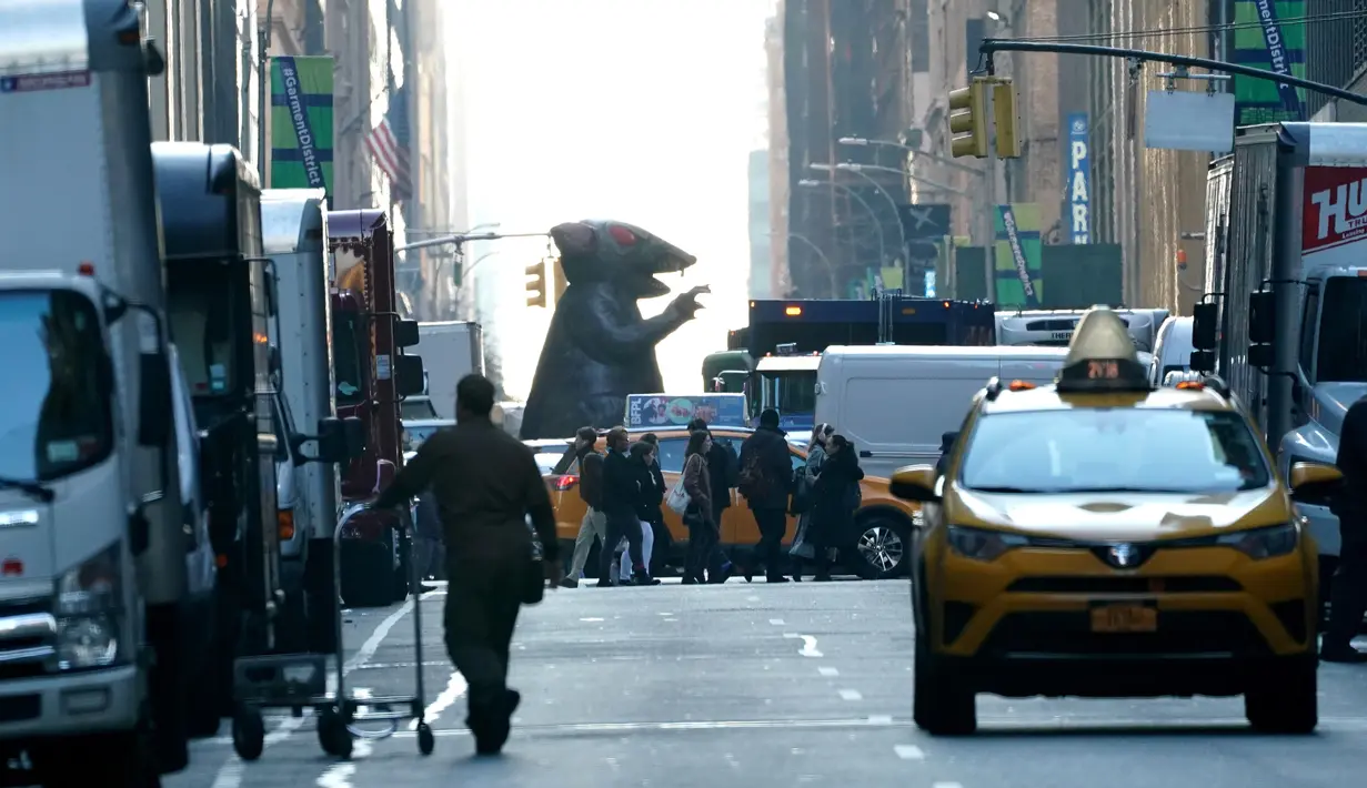 Balon tikus raksasa berjalan di tengah kota untuk diletakkan di luar kantor perusahaan sebagai simbol protes di New York, Kamis (26/12/2019). Serikat pekerja Amerika telah menggunakan balon tikus  untuk menyoroti praktik perburuhan yang tidak adil sejak 1990-an. (TIMOTHY A. CLARY/AFP)