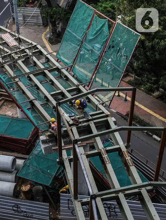 Pekerja menyelesaikan proyek pembangunan Jembatan layang (skybridge) CSW di Jakarta, Selasa (9/3/2021). Proyek pembangunan jembatan layang atau skybridge untuk integrasi Halte Transjakarta CSW di Stasiun MRT Asean ditargetkan selesai pada Mei 2021. (Liputan6.com/Johan Tallo)