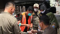 Warga yang terjaring razia masker didata petugas Satpol PP di kawasan Tanjung Duren, Jakarta, Kamis (19/11/2020). Satpol PP terus menindak warga yang melanggar protokol kesehatan selama PSBB transisi dengan sanksi kerja sosial di sarana umum atau membayar denda. (merdeka.com/Imam Buhori)