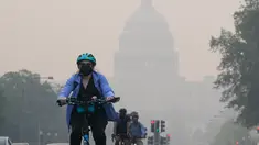 Seorang pengendara sepeda menggowes di bawah selimut kabut yang menutupi sebagian Capitol AS di Washington, DC, pada 8 Juni 2023. (Photo by Mandel NGAN / AFP)