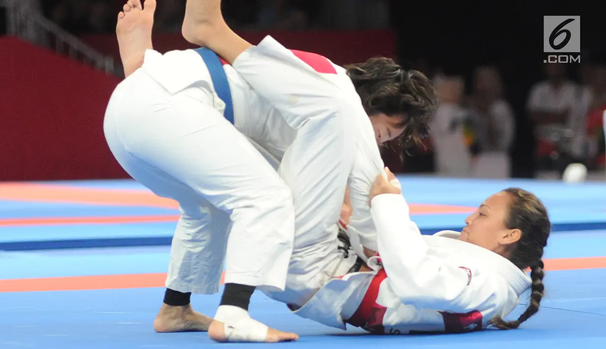 Atlet Jujitsu putri Mongolia Tsogkhuu Udval mengunci Simone Julia dari Indonesia saat bertanding pada nomor final putri 62 kg Asian Games 2018, Jakarta, Sabtu (25/8). Simone gagal mempersembahkan medali perunggu. (Merdeka.com/Arie Basuki)