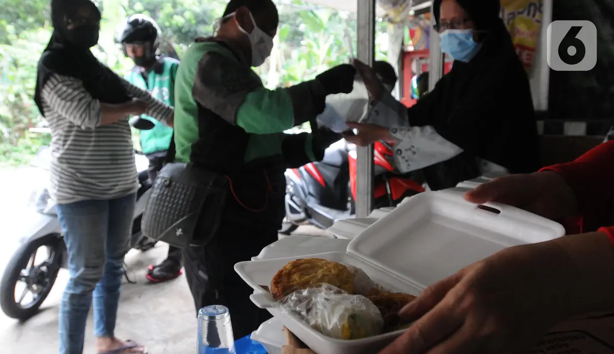 Relawan Yayasan Nasi Jumat (SiJum) Indonesia memberikan makan siang di Warung Makan Gratis Beji, Depok, Jawa Barat, Rabu (9/3/2022). Relawan menyediakan 100 porsi makanan sebagai bentuk kepedulian terhadap masyarakat yang ekonominya terdampak pandemi  COVID-19. (merdeka.com/Arie Basuki)