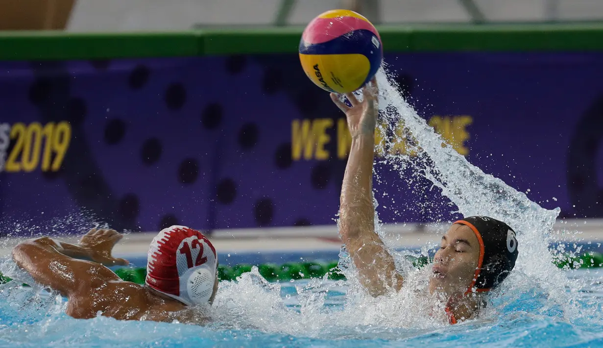 Pemain Malaysia Hang Toh Yi (kanan) berebut bola dengan pemain Indonsia Zaenal Arifin pada pertandingan polo air putra SEA Games 2019 di New Clark City, Tarlac, Filipina, Jumat (29/11/2019). Indonesia meraih medali emas setelah memuncaki klasemen dengan raihan 7 poin. (AP Photo/Aaron Favila)