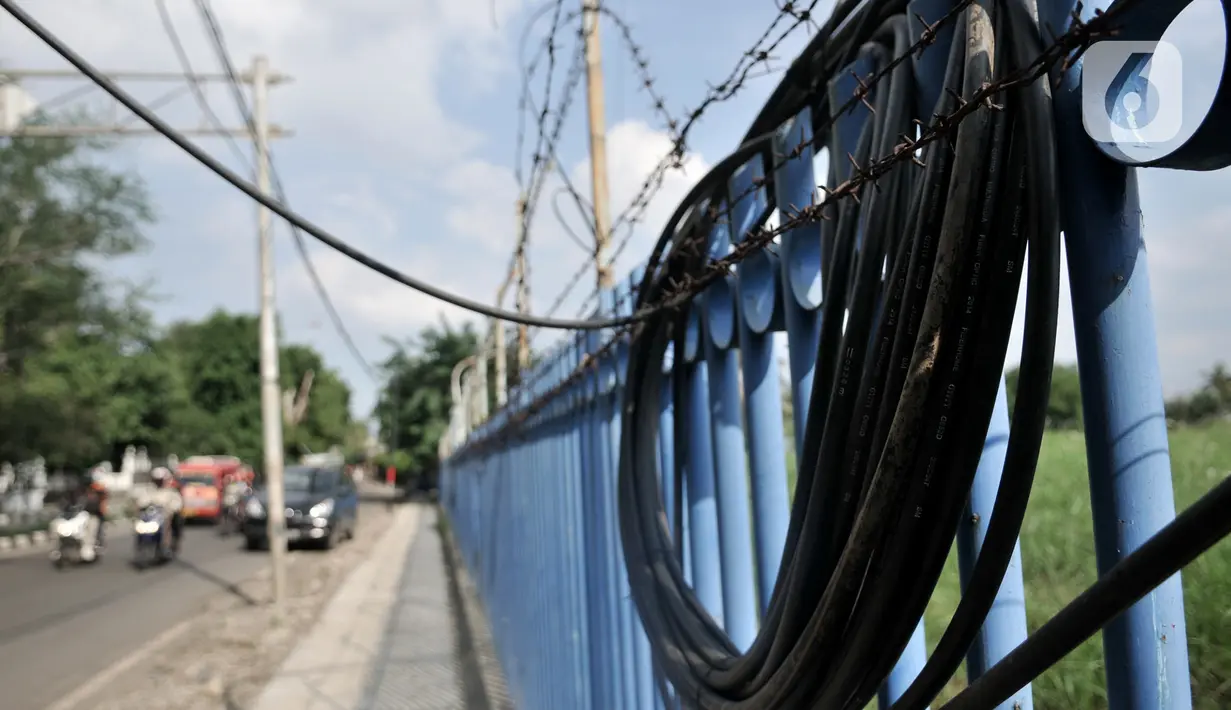 Kondisi salah satu kabel terkelupas di Jalan Jatinegara Kaum, Jakarta, Minggu (12/1/2020). Kurangnya pengawasan dalam penyelesaian proyek instalasi listrik bawah tanah PLN tersebut dapat membahayakan keselamatan pengendara serta pejalan kaki. (merdeka.com/Iqbal S. Nugroho)