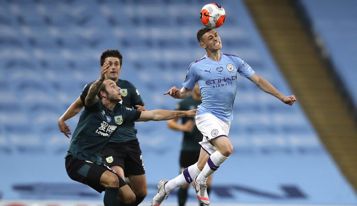 Pemain Manchester City, Phil Foden, menyundul bola saat melawan Burnley pada laga Premier League di Stadion Etihad, Senin (22/6/2020). Manchester City menang 5-0 atas Burnley. (AP/Shaun Botterill)