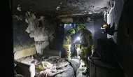 Tim penyelamat dari Layanan Darurat Negara Ukraina terus bekerja mencari korban di sebuah gedung bertingkat yang rusak akibat ledakan serangan pesawat tak berawak di Kyiv, pada tanggal 30 Oktober 2024. (Anatolii STEPANOV/AFP)