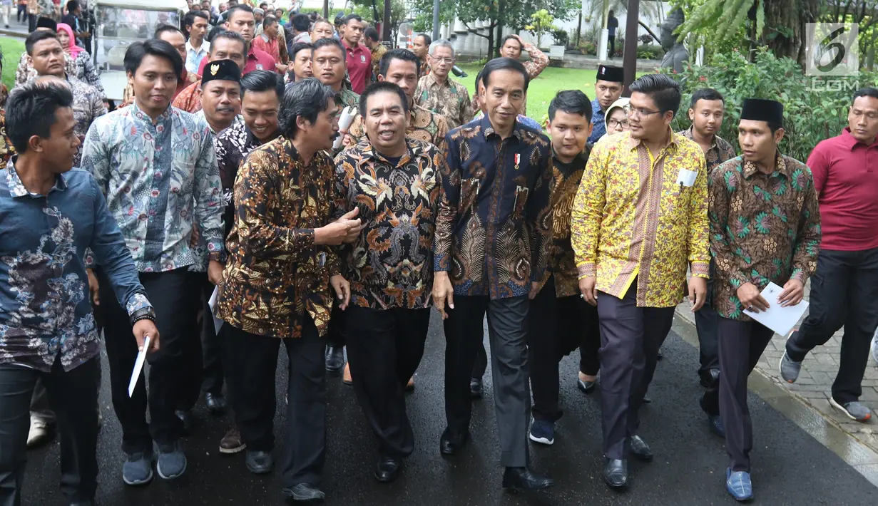 Presiden Joko Widodo atau Jokowi berjalan bersama perwakilan nelayan seluruh Indonesia di Istana Negara, Jakarta, Selasa (22/1). Jokowi mengingatkan para nelayan serta pengusaha perikanan untuk menggunakan Bank Mikro Nelayan. (Liputan6.com/Angga Yuniar)