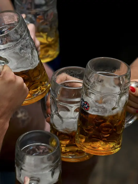 Penonton festival berdenting dengan gelas bir di tenda bir selama festival bir Oktoberfest di tempat pekan raya Theresienwiese di Munich, Jerman selatan (20/9/2022). Festival Bir yang terkenal di dunia ini akan berlangsung hingga 3 Oktober 2022 tanpa batasan akses, setelah dua hari terakhir edisi tahun telah dibatalkan karena pandemi coronavirus. (AFP/Christof Stache)