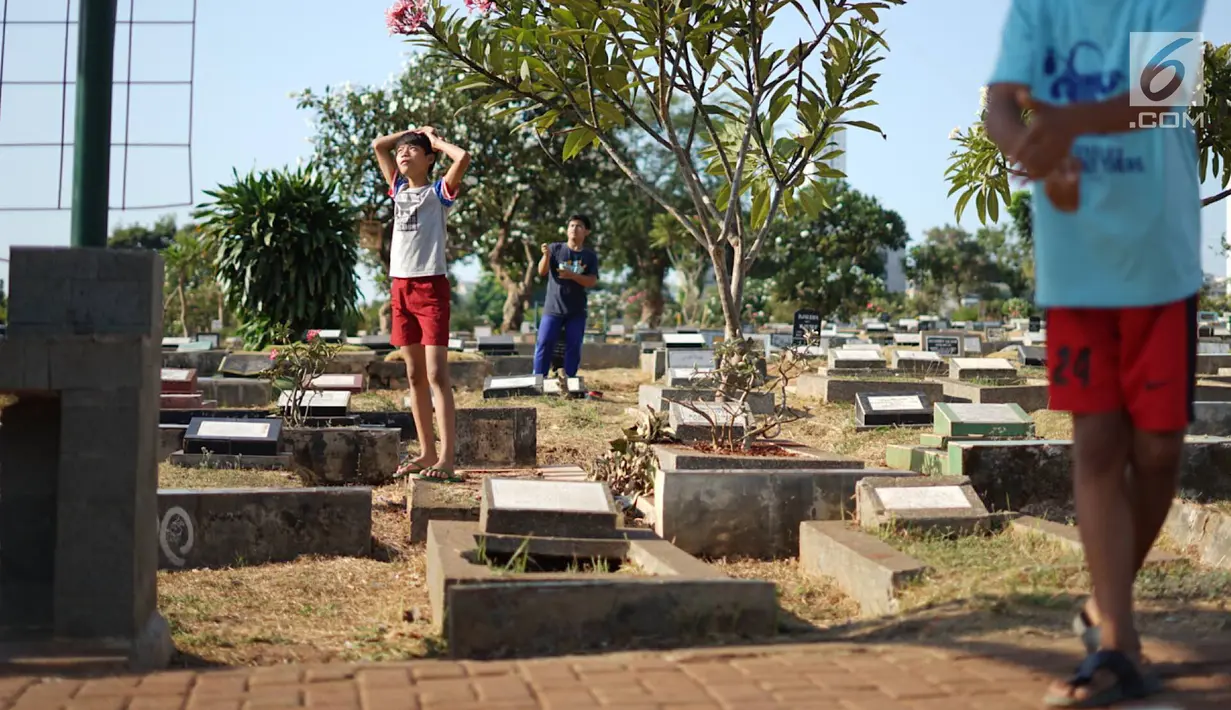 Anak-anak bermain di sekitar Taman Pemakaman Umum (TPU) Karet Bivak, Jakarta, Selasa (10/9/2019). Keterbatasan ruang terbuka hijau memaksa sebagian anak-anak di Ibu Kota bermain tidak pada tempatnya, meskipun dalam kondisi yang tidak layak. (Liputan6.com/Immanuel Antonius)