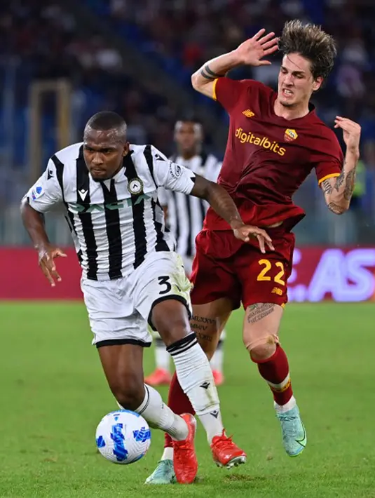 Pemain AS Roma Nicolo Zaniolo (kanan) berebut bola dengan pemain Udinese Samir pada pertandingan Serie A Liga Italia di Olympic Stadium, Roma, Italia, 23 September 2021. AS Roma menang 1-0. (Alberto PIZZOLI/AFP)