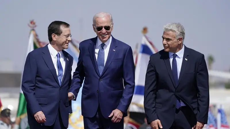 Presiden Joe Biden berdiri bersama Perdana Menteri Israel Yair Lapid (kanan) dan Presiden Isaac Herzog (kiri) setelah tiba di Bandara Ben Gurion, Rabu, 13 Juli 2022, di Tel Aviv. (Foto AP/Evan Vucci)