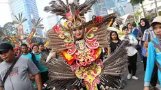 Seorang wanita dari kelompok seni budaya Kalimantan Selatan mengenakan pakaian adat berpawai saat pelaksanaan car free day, Jakarta, Minggu (1/7). Pawai tersebut diadakan untuk mengenalkan budaya Kalsel kepada masyarakat. (Liputan6.com/Immanuel Antonius)