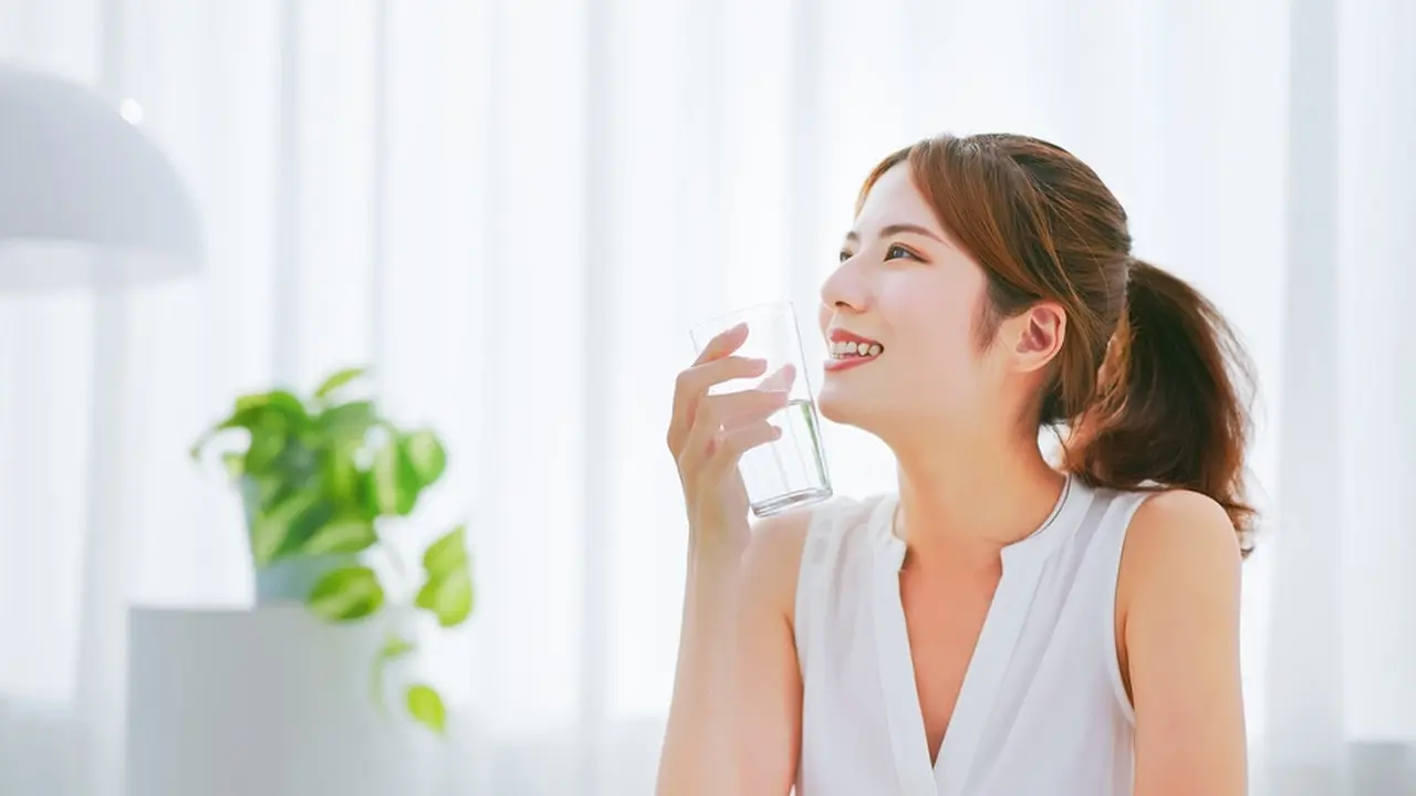 Perempuan sedang meminum air putih