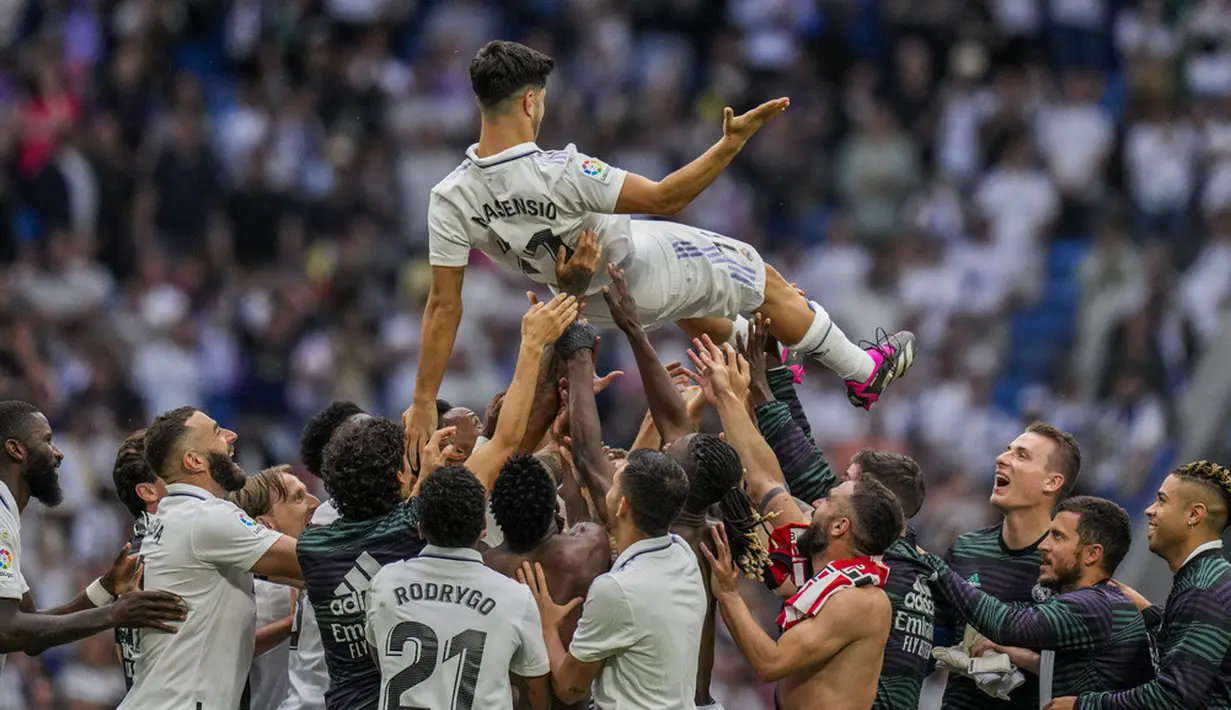 <p>Pemain Real Madrid Marco Asensio dilempar ke udara sebagai ungkapan selamat tinggal dari rekan setimnya setelah pertandingan sepak bola Liga Spanyol melawan Athletic Bilbao di Stadion Santiago Bernabeu, Madrid, Spanyol, Minggu (4/6/2023). (AP Photo/Bernat Armangue)</p>