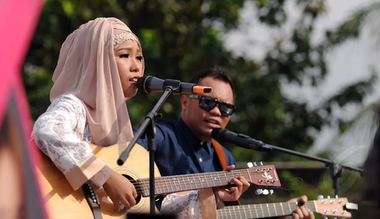 Pemenang pertama ajang Music Video Contest, Wiwi Handayani (kiri) berduet bersama Badai 'Kerispatih' di panggung inBox SCTV di Cibinong Square, Bogor, Jumat (30/1/2015). (Liputan6.com/Helmi Fithriansyah)