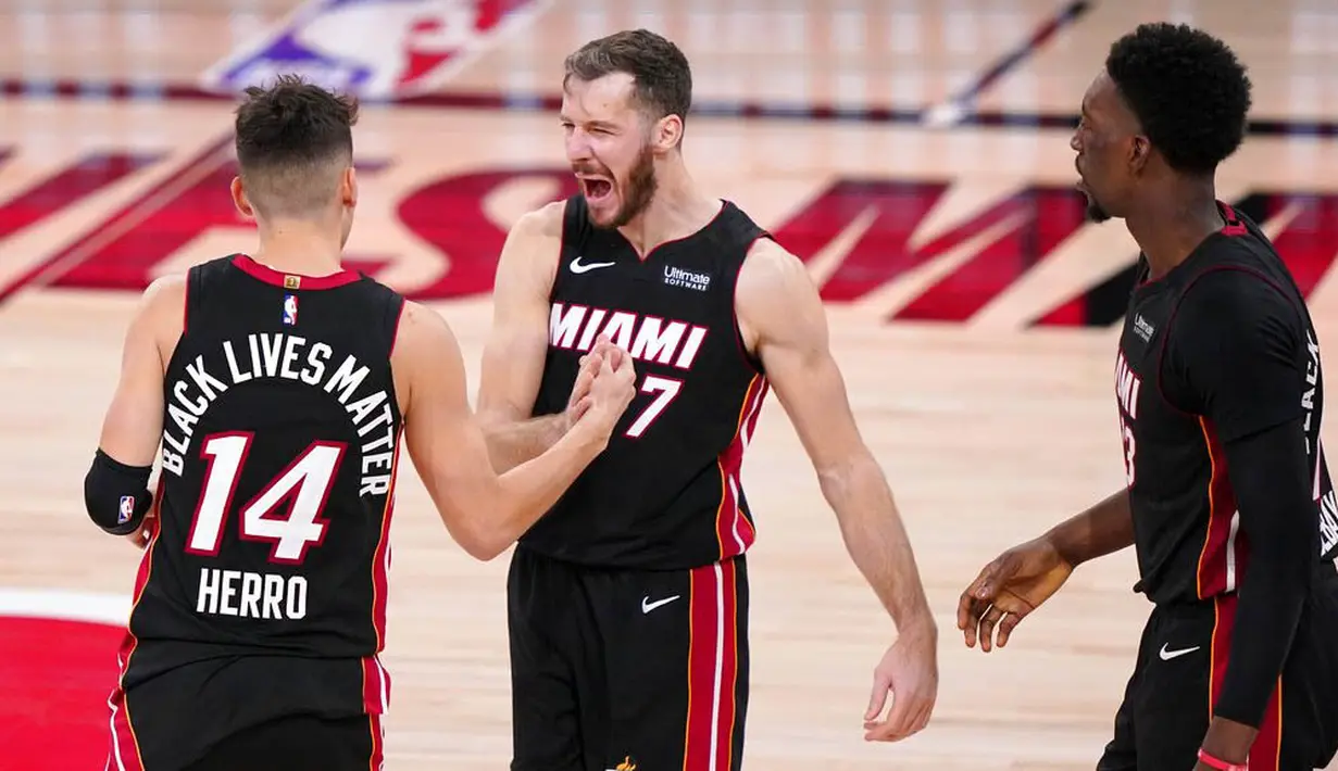 Pebasket Miami Heat, Tyler Herro, melakukan selebrasi bersama Goran Dragic usai menaklukkan Boston Celtics pada gim keempat final NBA Wilayah Timur di AdventHealth Arena, Kamis (24/9/2020). Miami Heat menang dengan skor 109-112. (AP/Mark J. Terrill)