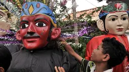Seorang anak menyiapkan ondel-ondel untuk mengamen di kawasan Senen, Jakarta, Kamis (27/12). Nantinya, pengamen ondel-ondel akan diberikan tempat khusus seperti di lokasi wisata. (Merdeka.com/Iqbal S. Nugroho)
