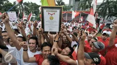 Warga binaan lapas Klas IIA Narkotika Cipinang mengangkat piagam penghargaan rekor MURI, Jakarta, Senin (15/8). Warga binaan raih rekor MURI untuk bernyanyi lagu nasional "Hari Merdeka" secara serentak oleh 150 ribu peserta. (Liputan6.com/Yoppy Renato)
