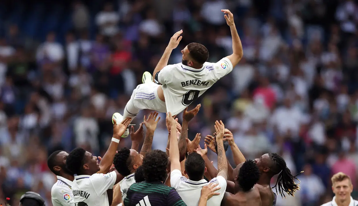 Sejumlah pemain Real Madrid melempar Karim Benzema ke udara sebagai bentuk perpisahan setelah pertandingan terakhirnya bersama Real Madrid melawan Athletic Bilbao di Santiago Bernabeu, Minggu (4/6/2023) malam WIB. (AFP/Pierre-Philippe Marcou)