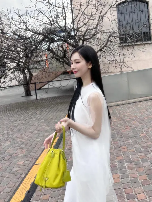 <p>Dalam acara ini, Karina mengenakan sleeveless dress berwarna putih berbahan lace. Dia memadukannya dengan tas Prada berwarna mustard. (Foto: Instagram/ katarinabluu)</p>