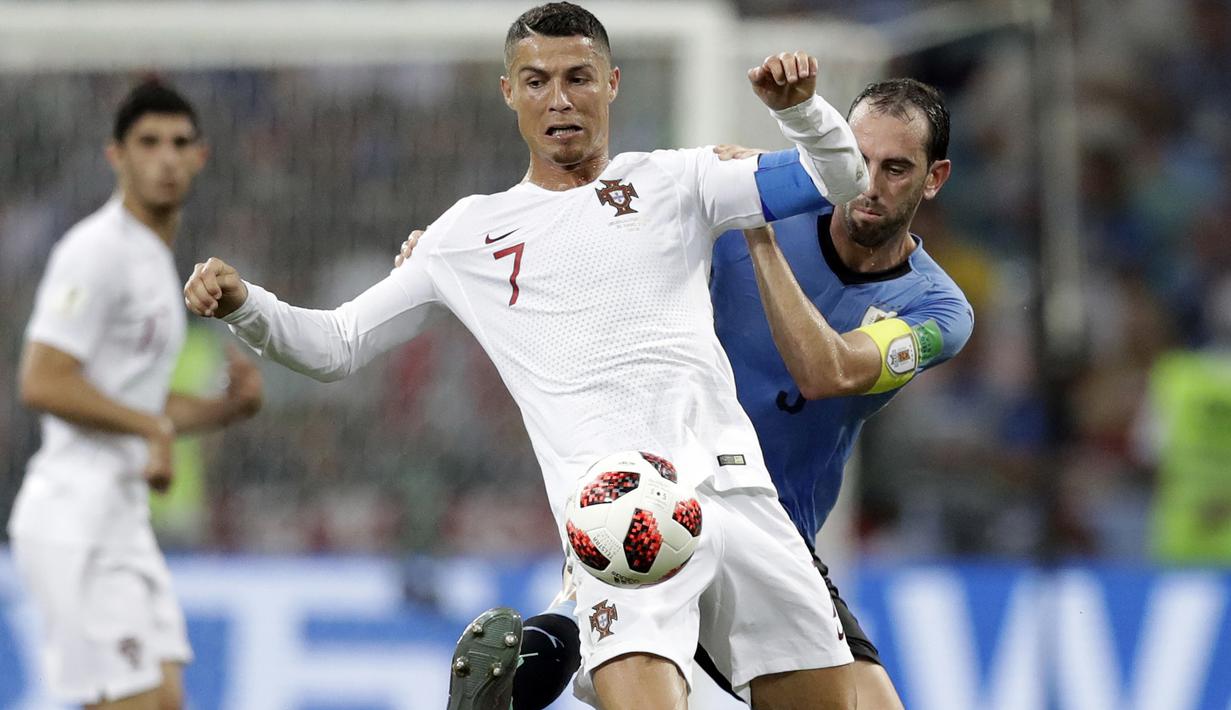 Cristiano Ronaldo (depan) berebut bola dengan pemain Uruguay, Diego Godin pada laga 16 besar Piala Dunia 2018 di Fisht Stadium, Sochi, Rusia, (30/6/2018). Portugal kalah 1-2 dari Uruguay. (AP/Andrew Medichini)