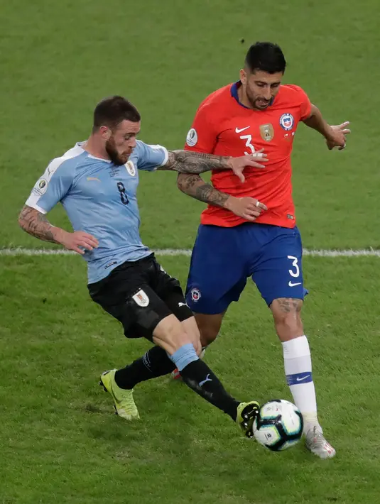 Gelandang timnas Uruguay, Diego Nahitan Nandez berebut bola dengan pemain Chile, Guillermo Maripan pada laga terakhir grup C Copa America 2019 di stadion Maracana, Senin (24/6/2019). Uruguay berhasil melaju ke perempatfinal dengan status juara Grup C usai mengalahkan Chile 1-0. (AP/Eraldo Peres)