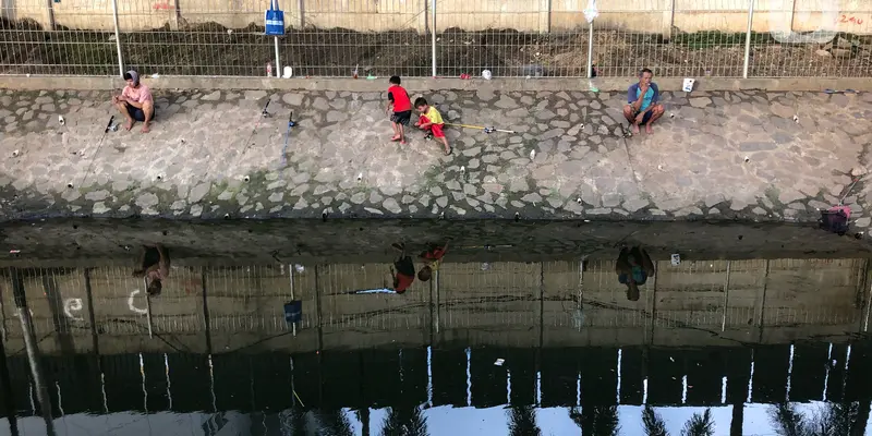 FOTO: Kubangan di Jalan DI Panjaitan Jadi Tempat Pemancingan Dadakan