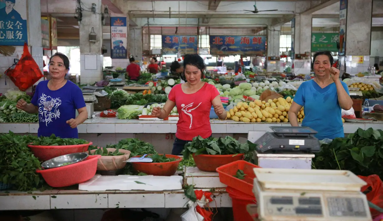 Sejumlah pedagang menari saat pembeli sedang sepi di sebuah pasar di Nanning, Provinsi Guangxi, China, Senin (5/6). Para pedagang menganggap joget bersama ini sebagai olahraga untuk menjaga kebugaran tubuhnya.  (Reuters/Stringer)