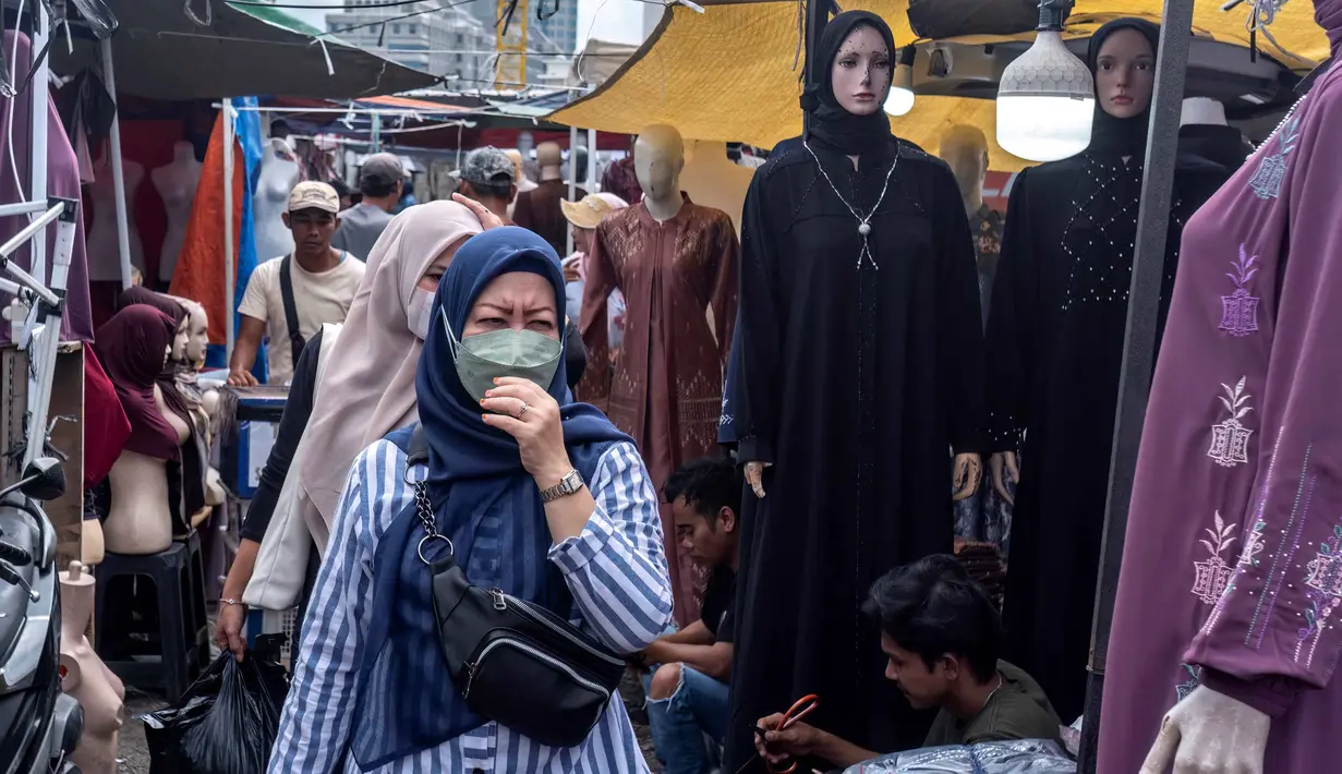 Pemerintah melalui Menteri Keuangan (Menkeu) Purbaya Yudhi Sadewa mengambil langkah tegas untuk menyetop impor pakaian bekas. Tampak dalam foto, pembeli berjalan di antara kios-kios penjual pakaian lokal di salah satu pasar tradisional, Jakarta, Kamis 20 November 2025. (BAY ISMOYO/AFP)