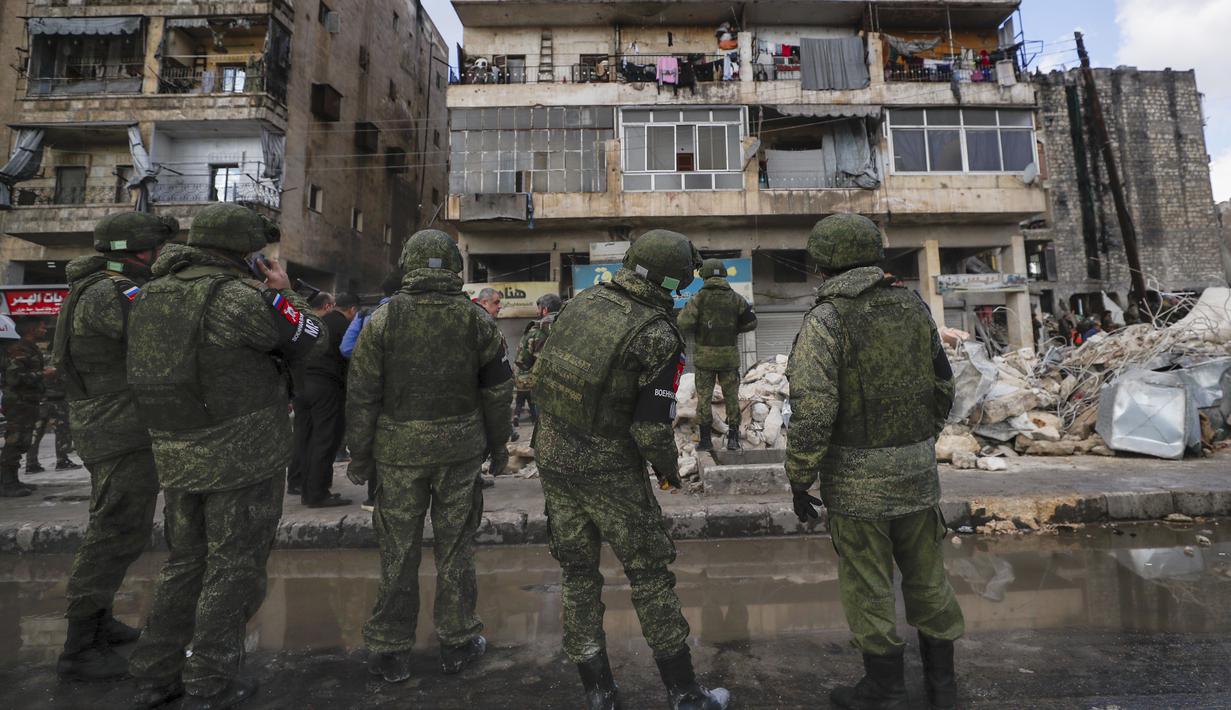 Tentara Rusia dan pasukan keamanan Suriah memeriksa puing-puing bangunan yang runtuh, di Aleppo, Suriah, Selasa, 7 Februari 2023. Tim penyelamat berlari pada Selasa untuk menemukan korban selamat di antara puing-puing ribuan bangunan yang runtuh akibat gempa kuat dan beberapa gempa susulan yang melanda Turki timur dan tetangga Suriah. (AP/Omar Sanadiki)