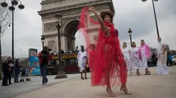 Seorang model ukuran plus bergaya saat tampil di depan Triump Arch di Paris, Prancis (4/1). Acara ini bertujuan mempromosikan keragaman yang bertema "All Sizes Catwalk". (AFP/Thomas Samson)