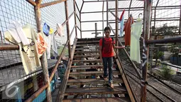 Warga menuruni anak tangga di Jembatan Penyeberangan Orang yang rusak di kawasan Tebet, Jakarta, Kamis (5/11). Kondisi jembatan yang sudah berkarat dan berlubang tersebut membahayakan pejalan kaki terutama saat malam hari. (Liputan6.com/Immanuel Antonius)