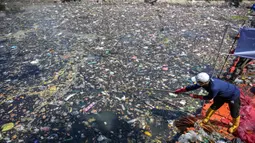 Kegiatan ini bertujuan mengubah citra Kali Tebu dari sungai yang penuh sampah menjadi sarana wisata air dan ruang publik bagi warga sekitar. Tampak dalam foto, aktivis dari Ecoton (Ecological Observation and Wetlands Conservation) bersama pekerja dari Dinas Lingkungan Hidup Pemerintah Kota Surabaya, Jawa Timur, membersihkan sampah dari Sungai Kali Tebu, pada Senin 11 Mei 2026. (JUNI KRISWANTO/AFP)