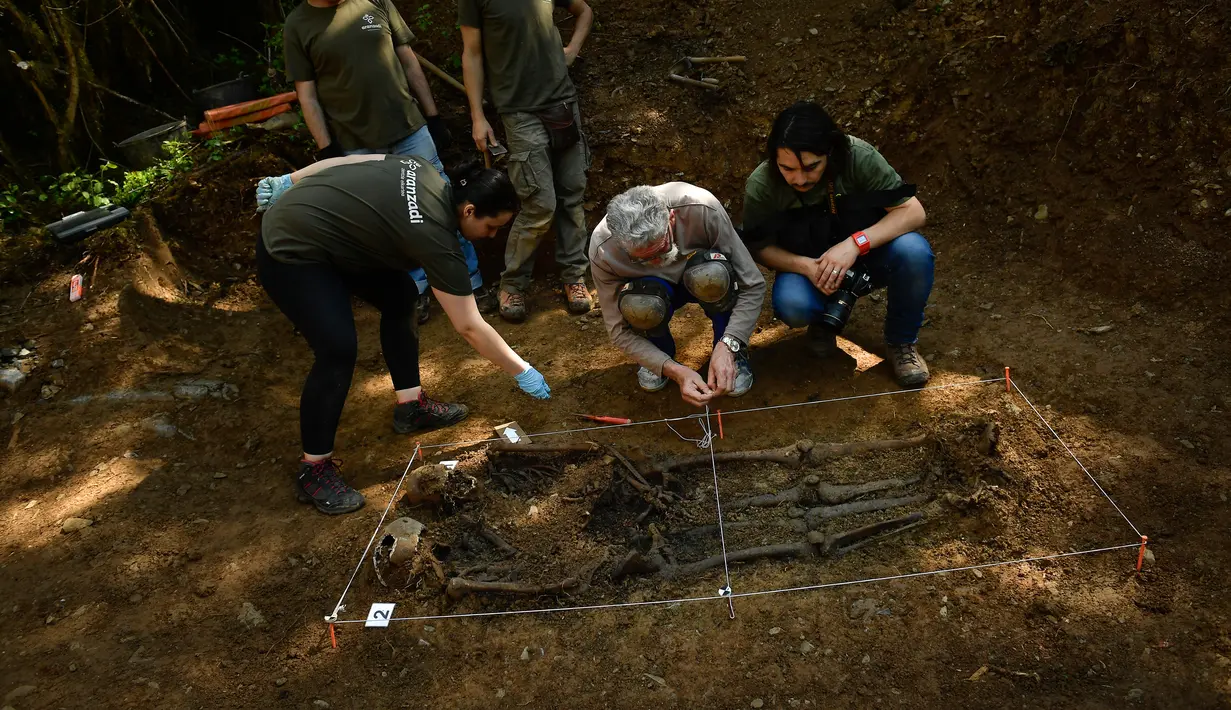 Arkeolog memasang garis saat memeriksa kuburan yang diyakini berisi dua tahanan republik yang tewas selama Perang Saudara Spanyol di Leranoz, Pyrenees, sekitar 30 km (21,78 mil) dari Pamplona, Spanyol utara, Selasa (22/5). (AP Photo/Alvaro Barrientos)