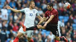 Striker Inggris, Harry Kane, berusaha melewati bek Turki, Hakan Balta, pada laga persahabatan. Bomber Tottenham ini berhasil membobol gawang Turki pada menit ketiga. (AFP/Paul Ellis)