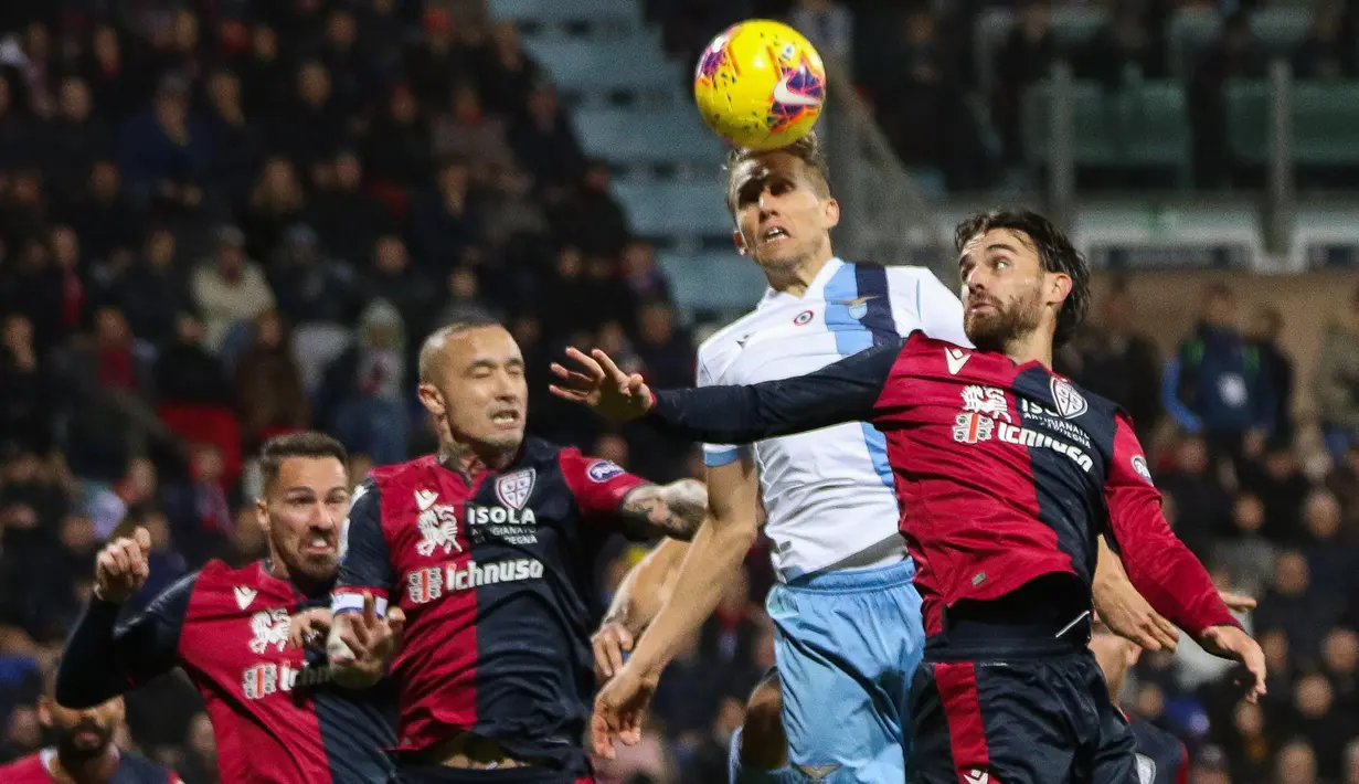 Gelandang Lazio, Lucas Leiva (tengah) berusaha menyundul bola saat bertanding melawan Cagliari pada pertandingan lanjutan Liga Serie A Italia di Sardegna Arena, pulau Sardinia (16/12/2019). Lazio menang dramatis 2-1 atas Cagliari. (AP Photo/Fabio Murru)
