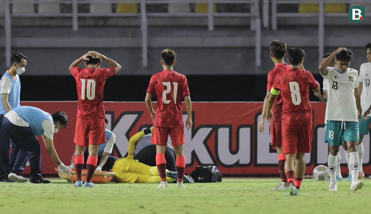 Kiper Timnas Indonesia U-20, Cahya Supriadi mendapatkan pertolongan pertama dari tim medis usai mengalami cedera dalam pertandingan matchday kedua Kualifikasi Grup F Piala Asia U-20 2023 di Stadion Gelora Bung Tomo, Surabaya, Jumat (16/9/2022). (Bola.com/Ikhwan Yanuar)