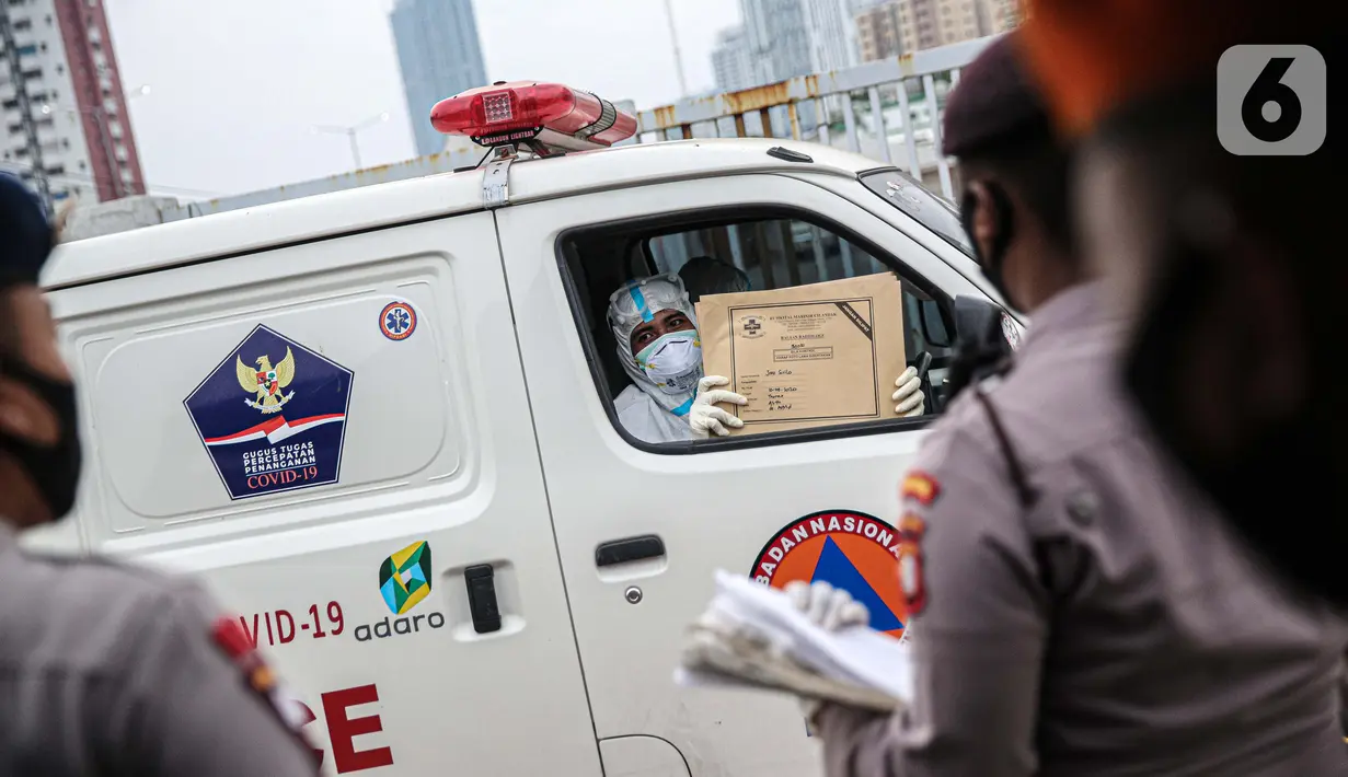 Petugas medis menunjukkan berkas saat melewati petugas jaga di Rumah Sakit Darurat Wisma Atlet, Kemayoran, Jakarta, Kamis (10/9/2020). Sebanyak 1.600 dari 2.700 tempat tidur yang disiapkan pemerintah untuk pasien COVID-19 di RSD Wisma Atlet telah terisi. (Liputan6.com/Faizal Fanani)