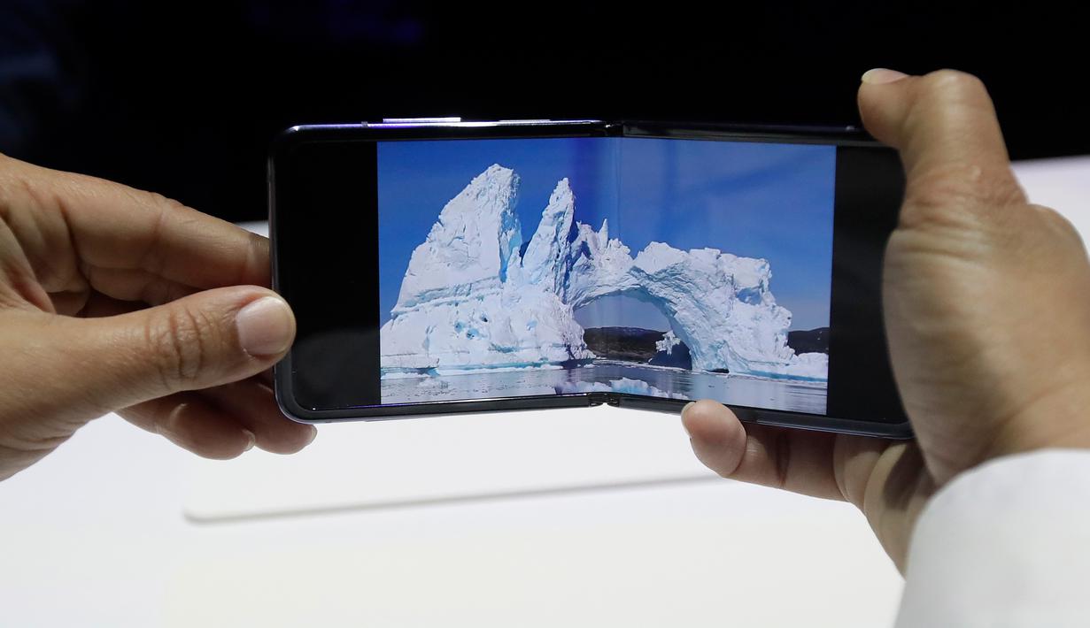 Seorang pekerja Samsung mendemonstrasi Galaxy Z Flip yang ditampilkan pada acara Unpacked 2020 di San Francisco, Selasa (11/2/2020). Untuk kamera, Galaxy Z Flip dibekali kamera 12MP dan kamera dengan sudut pandang lebar 123 derajat, serta kamera depan 10MP. (AP/Jeff Chiu)