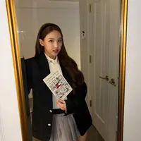 Nayeon tampil dengan blazer hitam oversize yang dikenakan sebagai luaran, dipadukan inner kemeja dan vest knit. Serta bawahan mini skirt pleated abu-abu. [@nayeonyny]