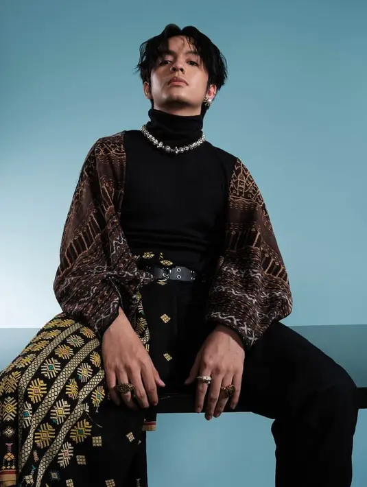 Salah satunya seperti aktor tampan yang sedang naik daun, Angga Yunanda tampil mengenakan turtleneck top hitam, dipadukan outer dan aksesori kalung Manjusha Nusantara. Serta kain tenun Ende.  (Foto:Instagram/akudankain).