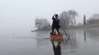 Sesosok pria mengenakan tuksedo tampak mengayuh peti mati di atas danau yang berkabut. Hal ini membuat takut masyarakat di sekitar danau