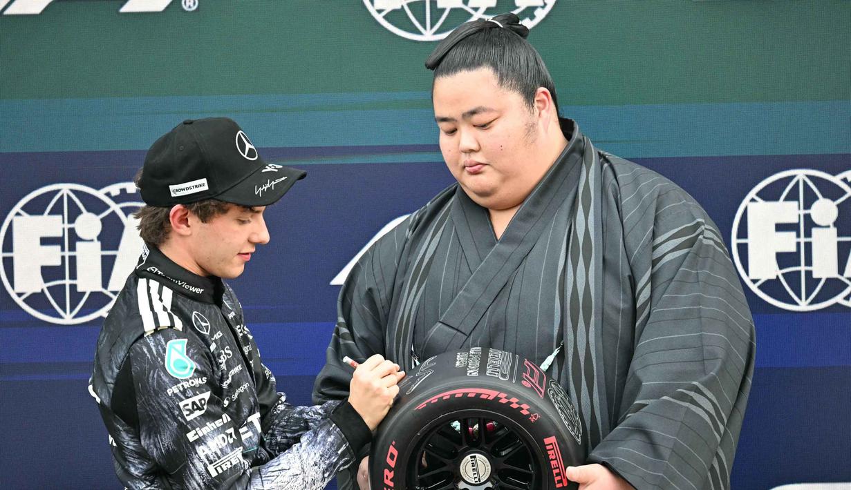 Untuk posisi keempat dan kelima masing-masing ditempati oleh pembalap Scuderia Ferrari HP, Charles Leclerc, dan pembalap McLaren Mastercard F1 Team, Lando Norris. Tampak dalam foto, pembalap Mercedes AMG Petronas asal Italia, Kimi Antonelli, menerima penghargaan pole position dari pegulat sumo Jepang, Kotozakura Masakatsu II, setelah sesi kualifikasi Formula 1 GP Jepang 2026 di Sirkuit Suzuka, pada Sabtu (28/3/2026). (Toshifumi KITAMURA/AFP)