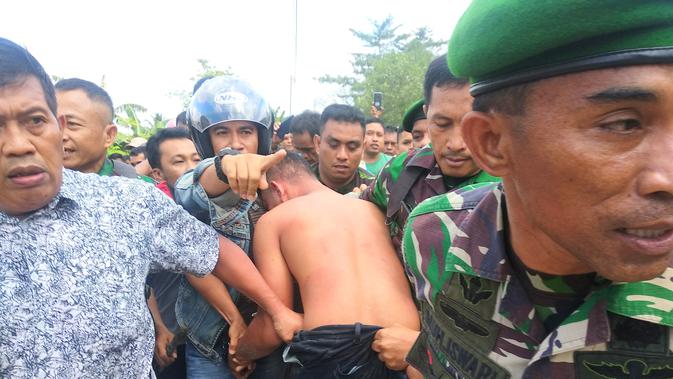 Adrianus Pattian, mantan TNI pelaku penculikan dan pedofil 6 bocah di Kendari, berhasil ditangkap saat bersembunyi di rumah warga. (Liputan6.com/ Ahmad Fua)