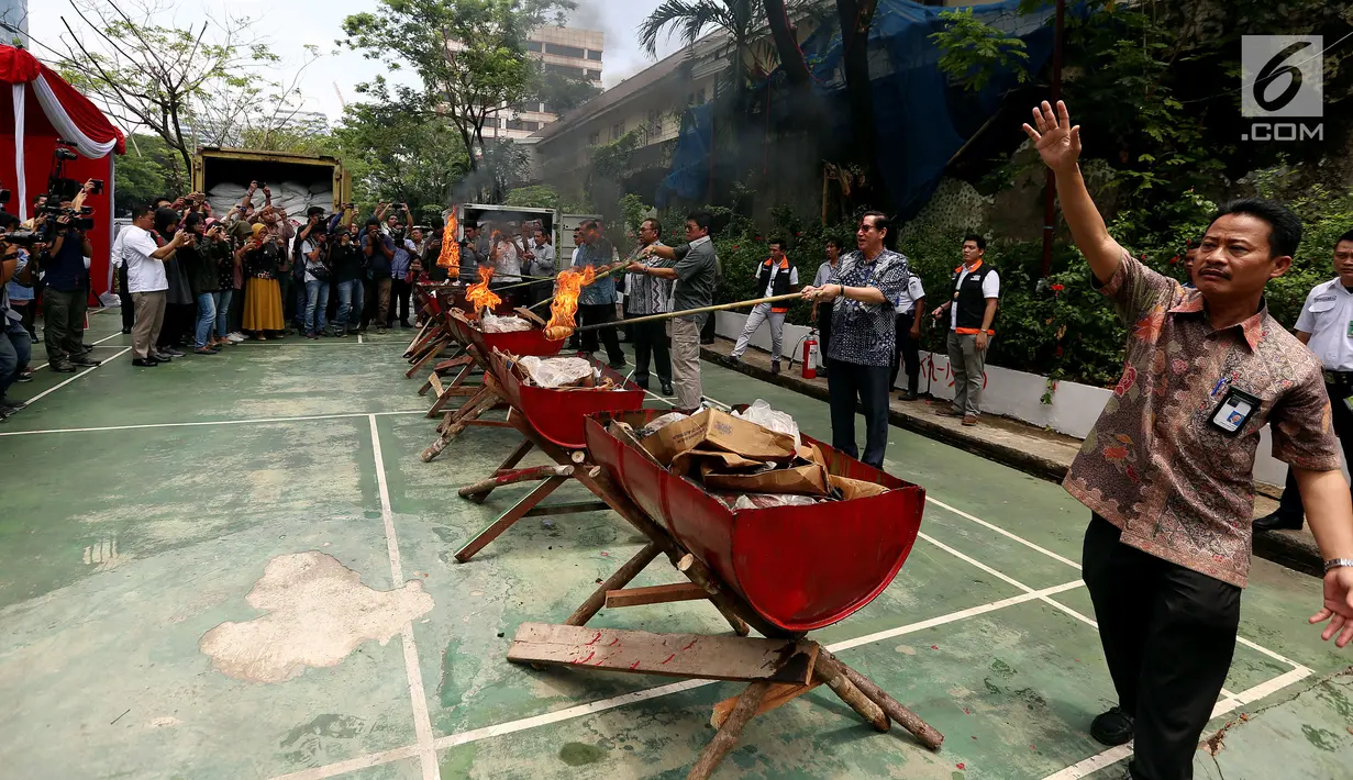 Petugas membakar gula kristal dan daging beku yang sudah kedaluwarsa hasil sitaan di Kemendag, Jakarta Kamis (28/9). (Liputan6.com/JohanTallo)