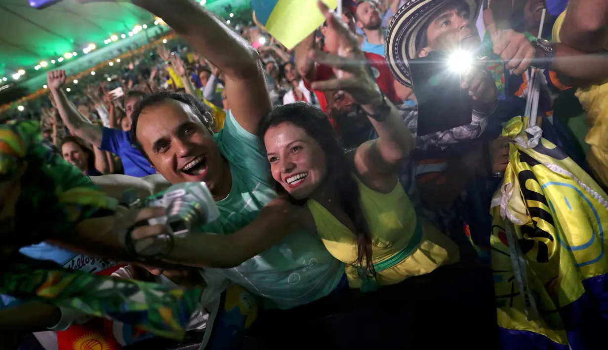 Suporter wanita Brasil bersemangat menyaksikan pembukaan Olimpiade 2016 di Rio de Janeiro, Brasil, (6/8). Pembukaan olimpiade 2016 ini menyambut 10.500 atlet lebih dari 200 negara di seluruh dunia. (REUTERS/Mike Blake)