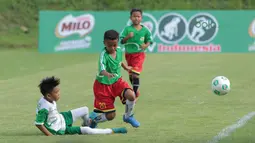 Pemain Al Hidayah (kiri) menghalau bola dari pemain SD Angkasa 9 pada ajang MILO Football Championship 2018 di Lapangan Panahan GBK, Jakarta, (24/3/2018). Sekitar 128 sekolah dasar di Jakarta meramaikan ajang tersebut. (Bola.com/Nick Hanoatubun)
