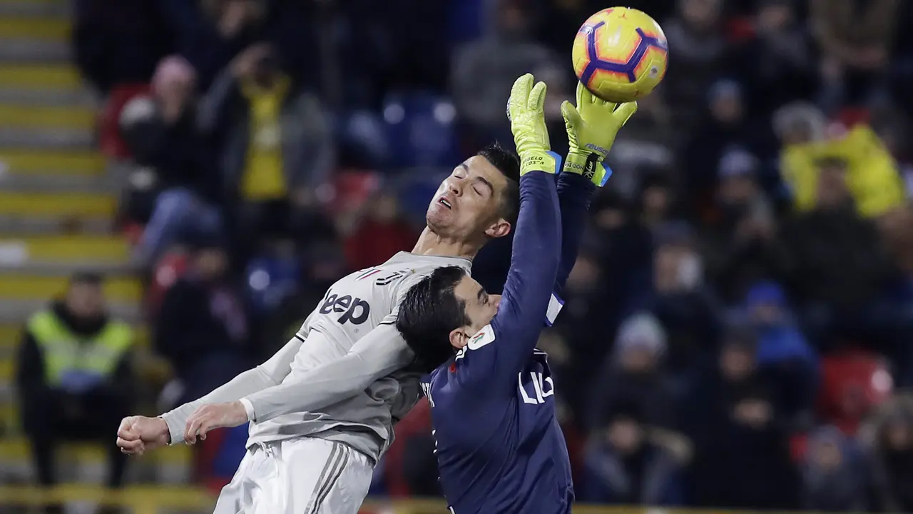 Kiper Bologna, Esmael Da Costa, duel udara dengan gelandang Juventus, Cristiano Ronaldo. (AP/Luca Bruno)